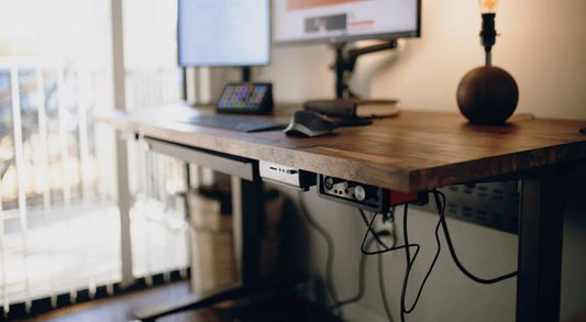 An ergonomic standing desk in a home workspace setup with monitor stand